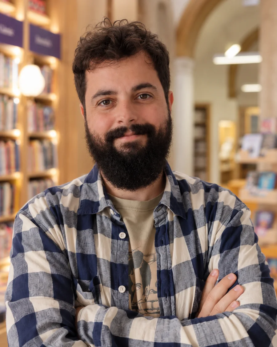 Retrato de Víctor Corrales, con camisa de cuadros, en una librería.